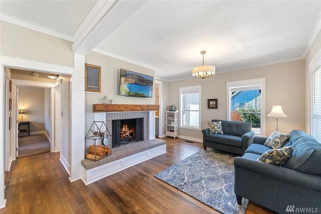 A living room with hardwood floors and fireplace.