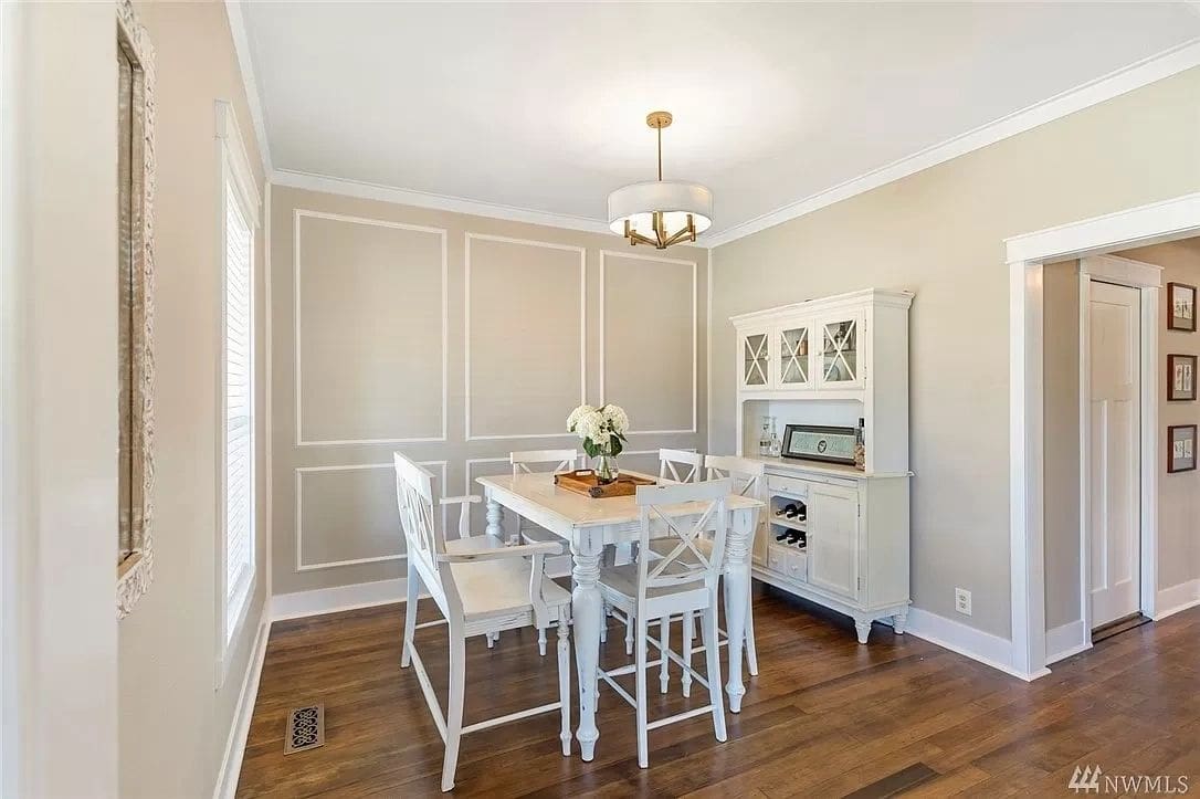 A dining room with white chairs and table