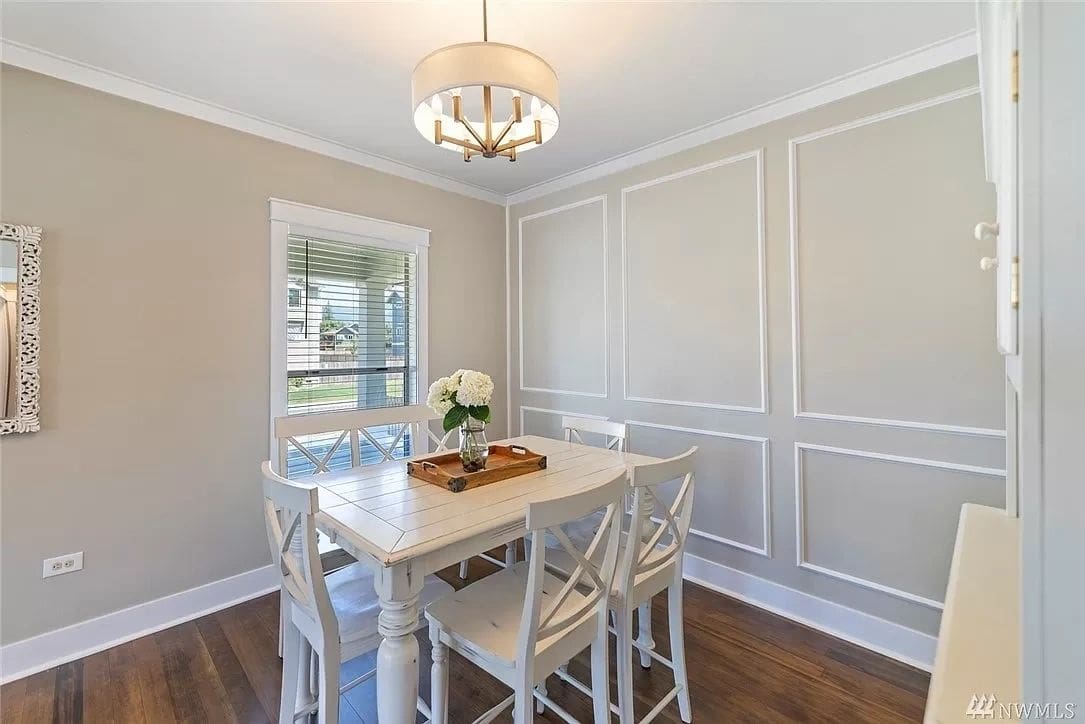 A dining room with white chairs and table