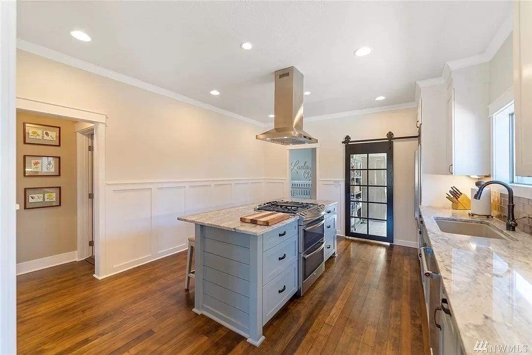 A kitchen with wood floors and white walls.