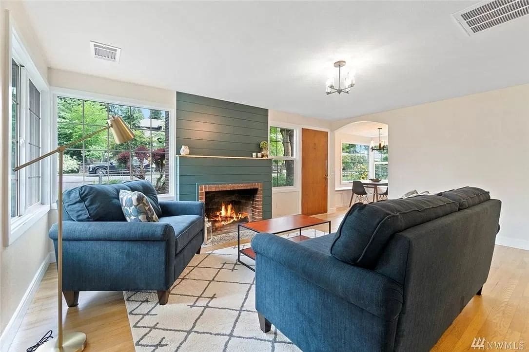 A living room with blue couches and fireplace.