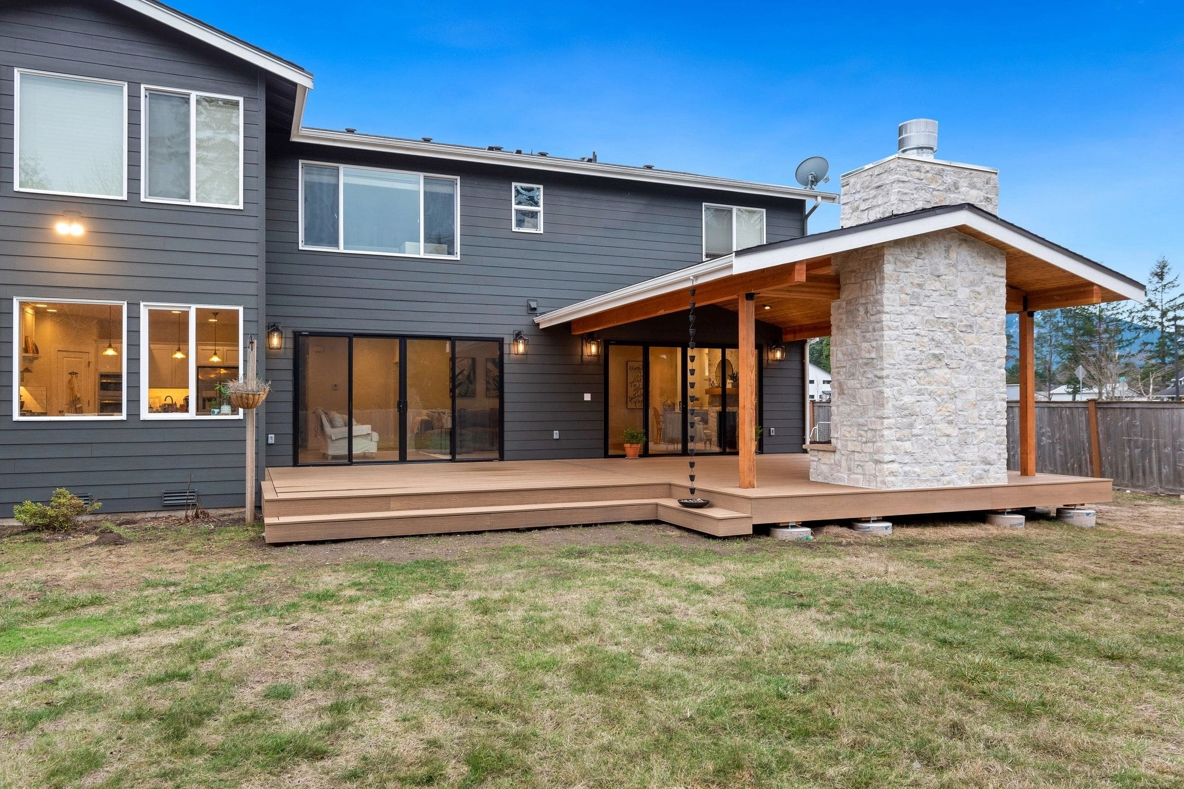 A large backyard with a covered patio and grass.