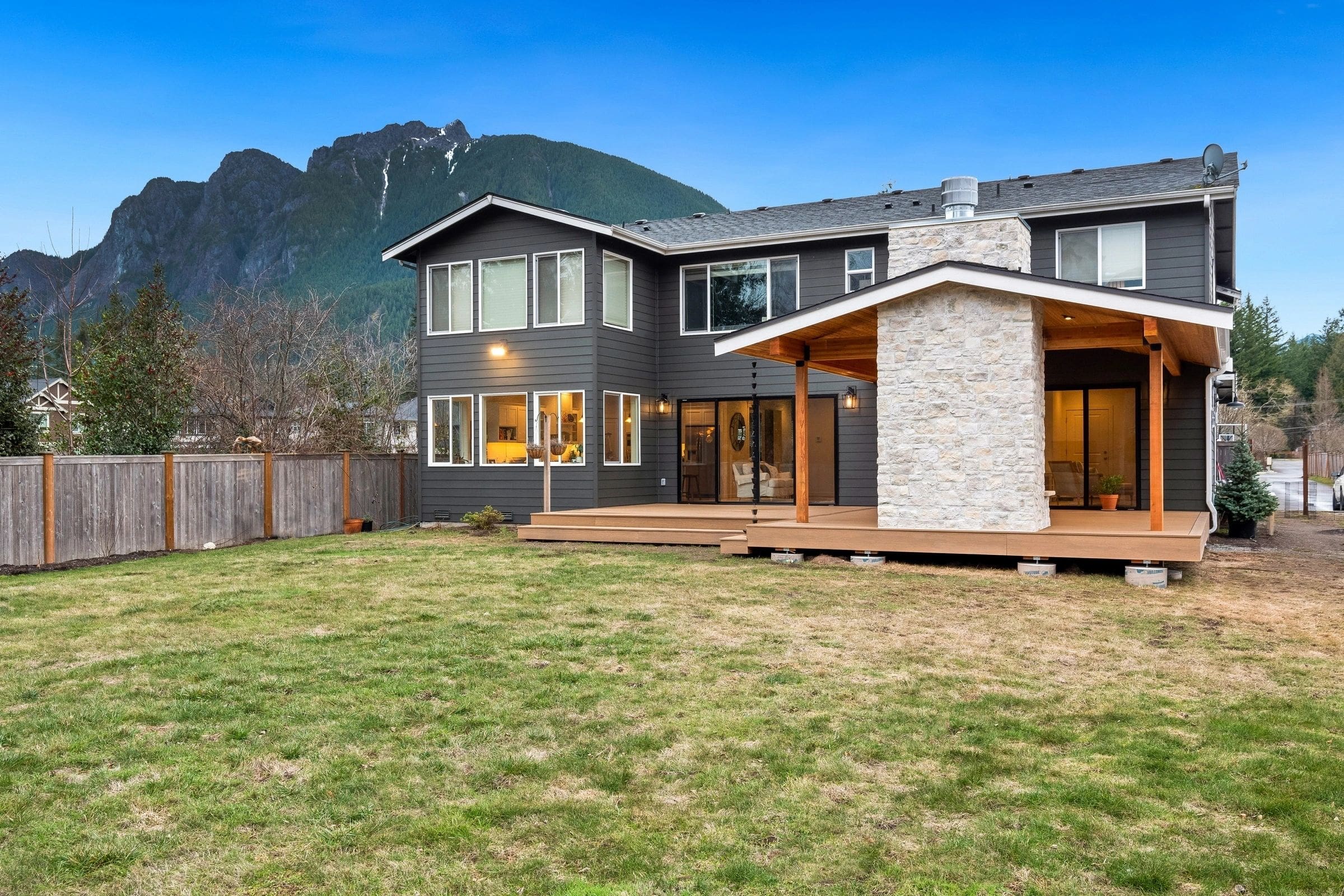 A large backyard with grass and trees in the background.