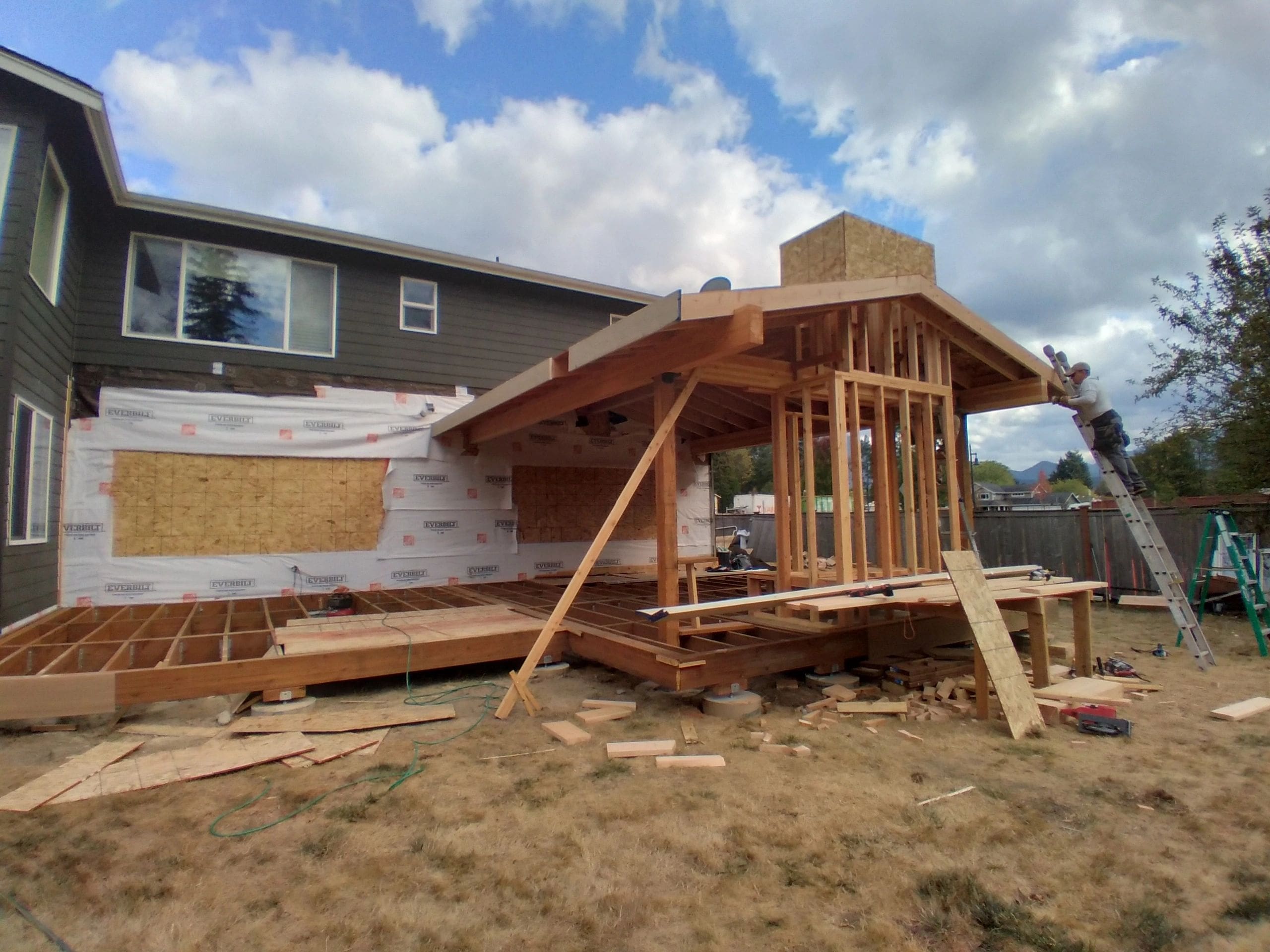 A house being built with wood framing and a wooden beam.