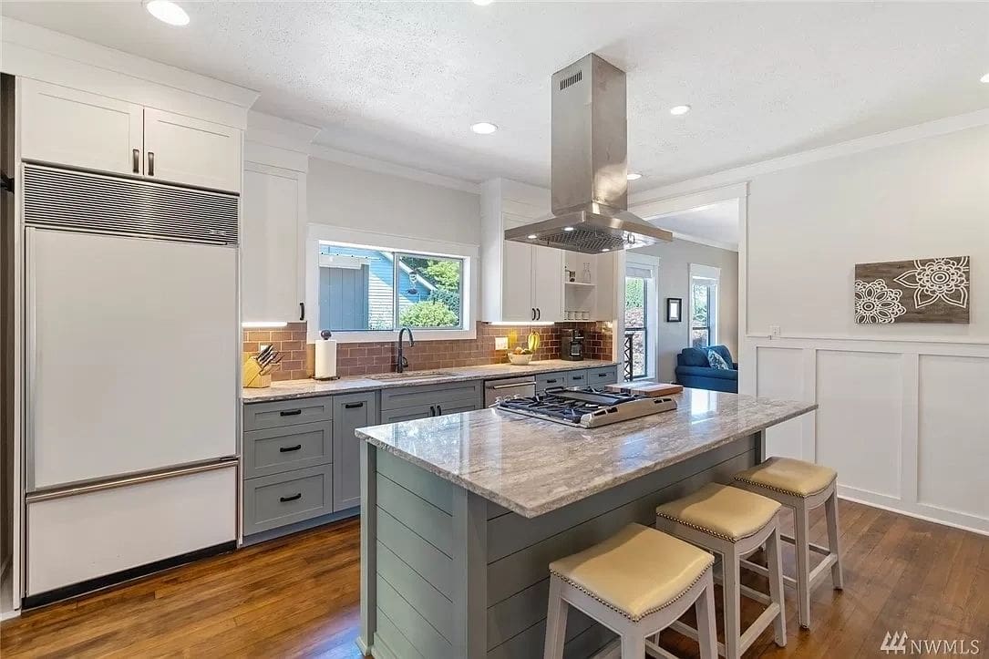 A kitchen with a stove and island in it