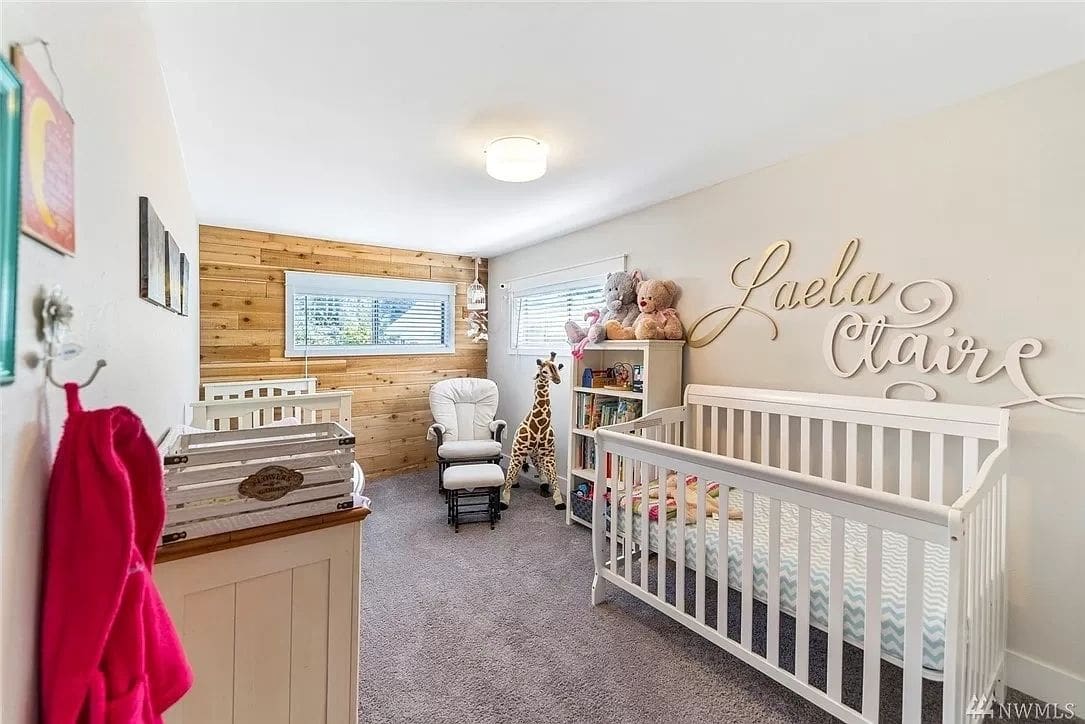 A baby room with two cribs and a rocking chair.