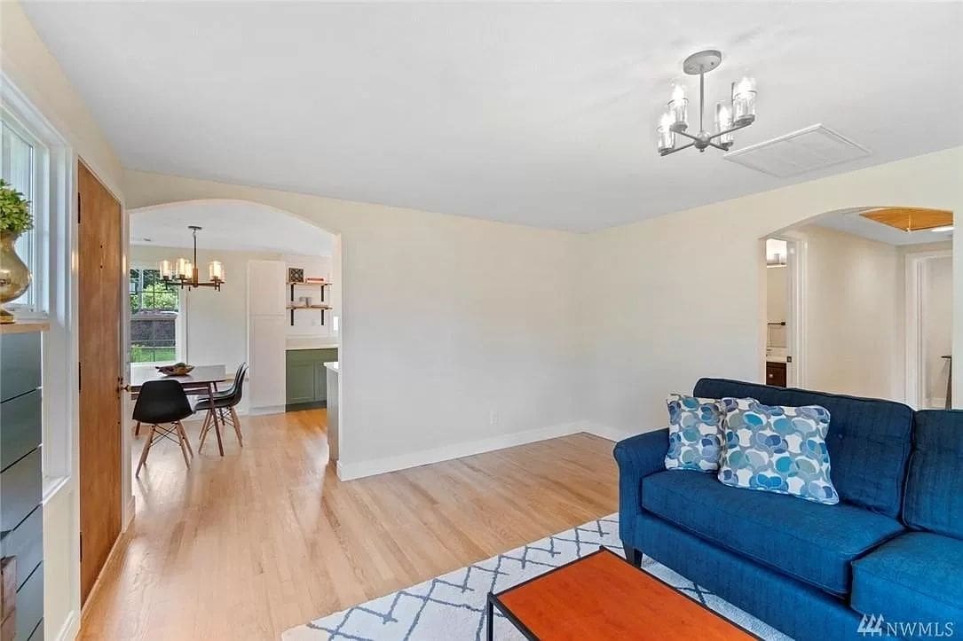 A living room with hard wood floors and white walls.