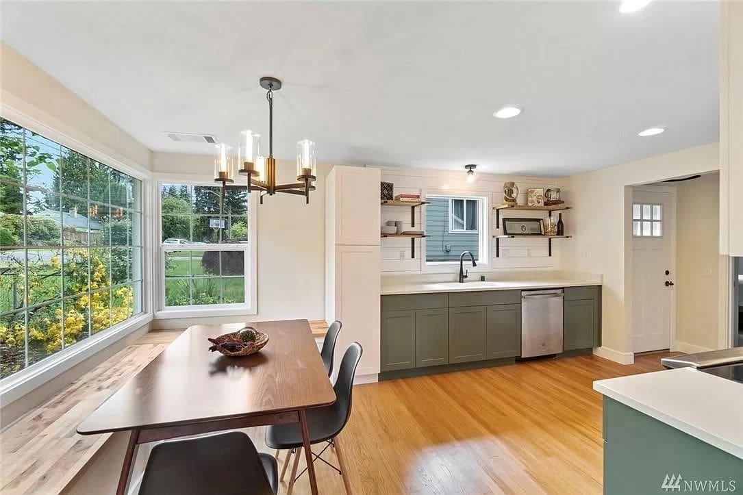 A dining room table and chairs in the middle of a kitchen.