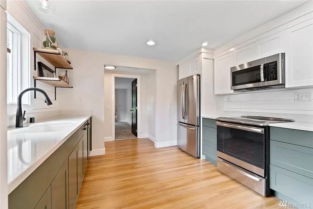 A kitchen with wood floors and stainless steel appliances.