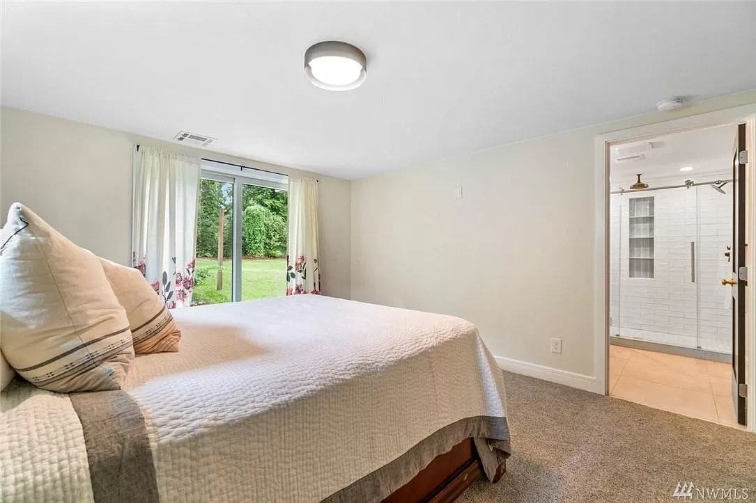 A bedroom with a large bed and sliding glass doors.