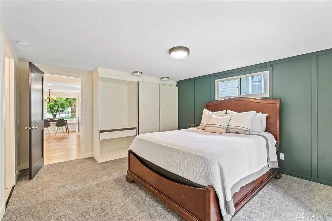 A bedroom with a bed, closet and window.