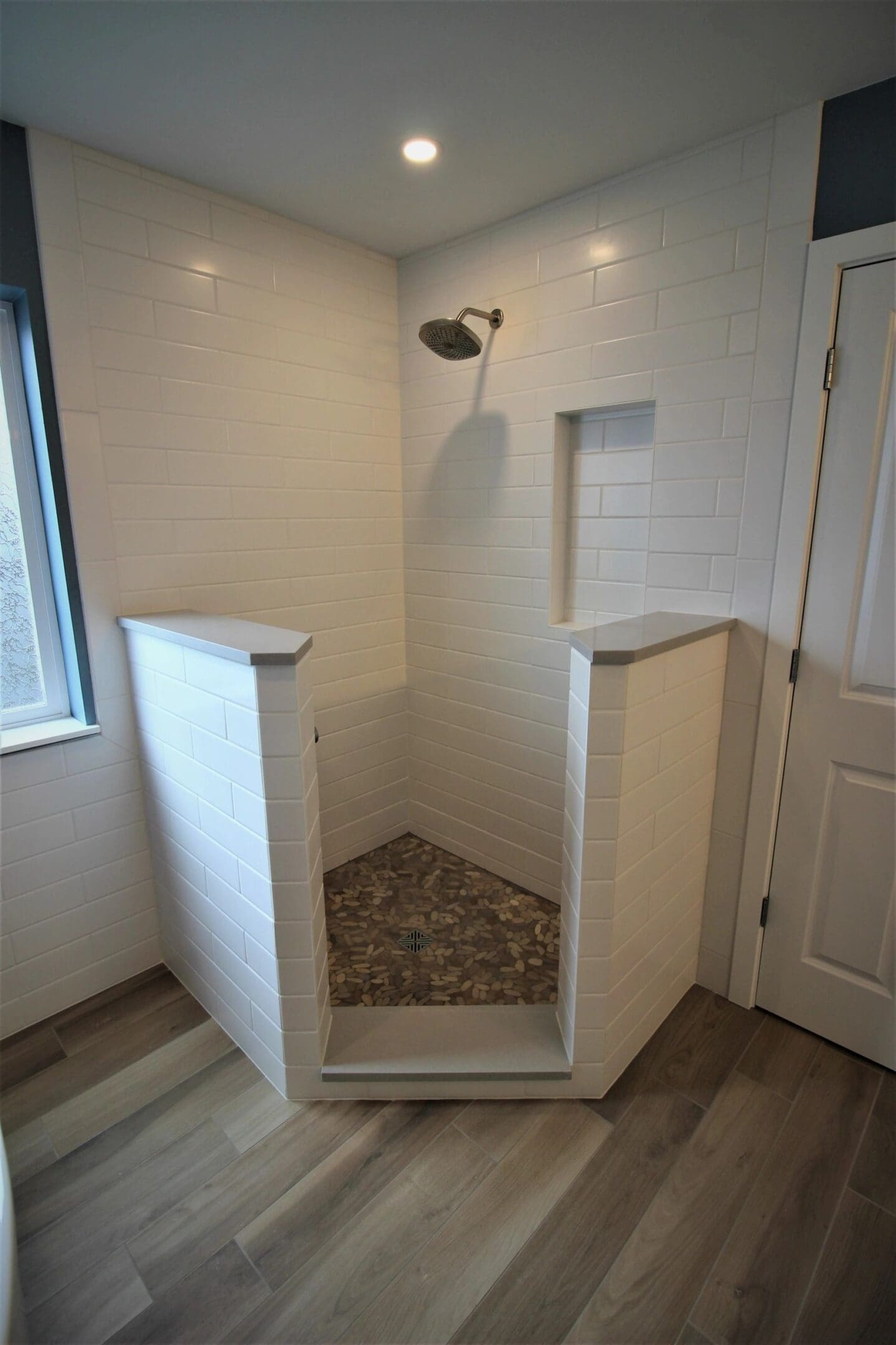 A walk in shower with tiled walls and floor.