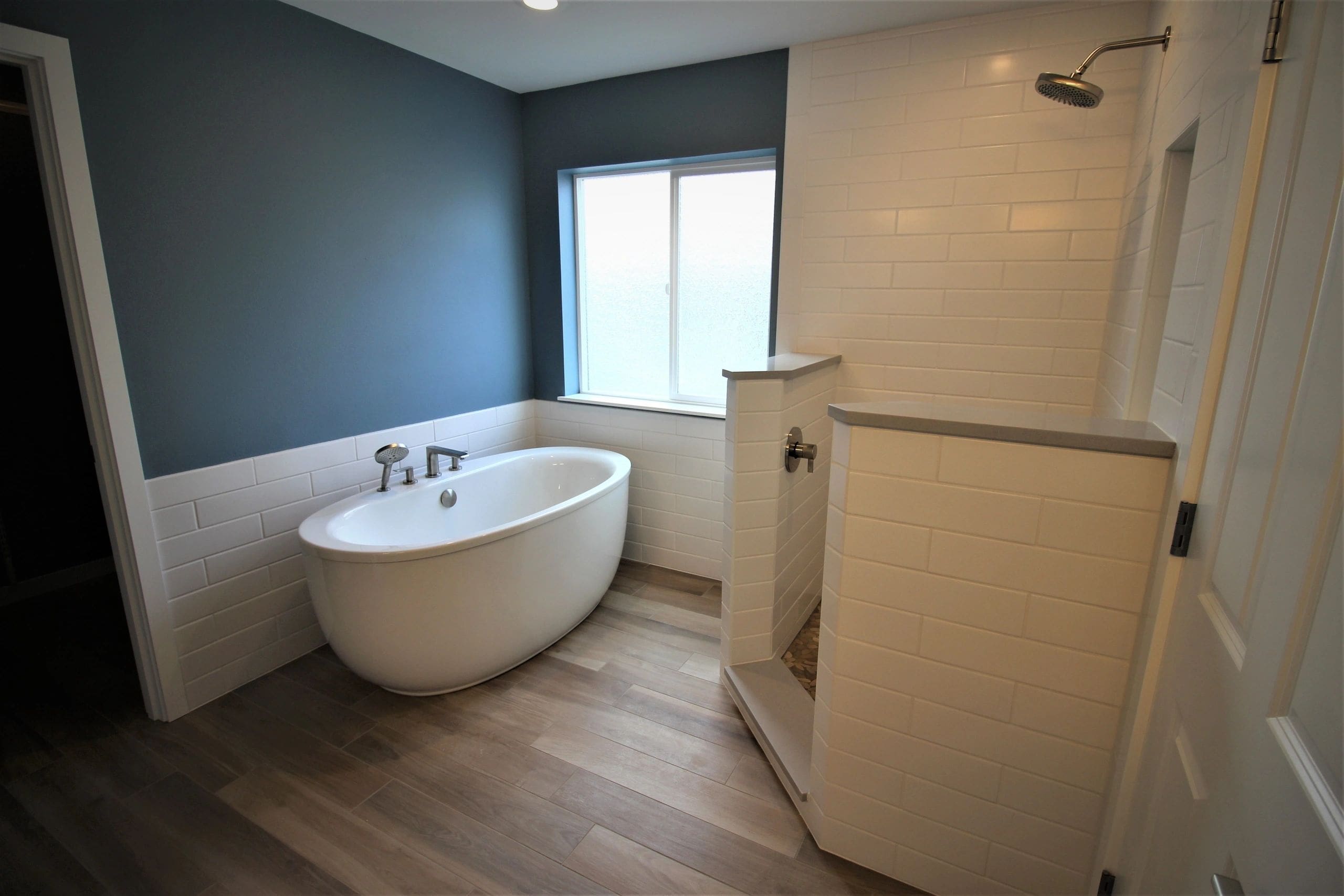 A bathroom with a tub, toilet and shower.