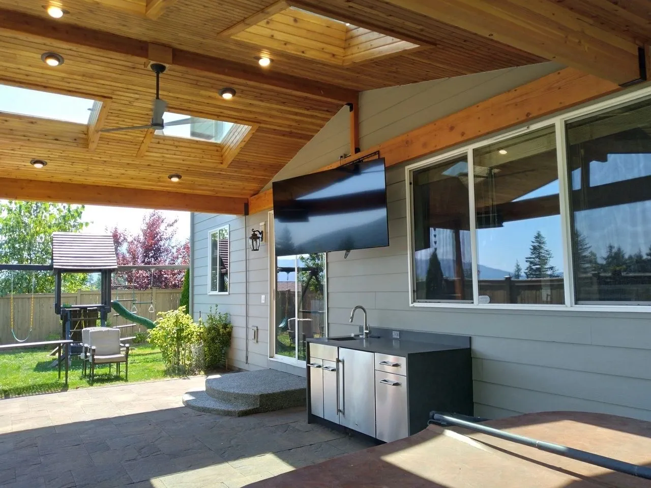 A large outdoor kitchen with an entertainment system.